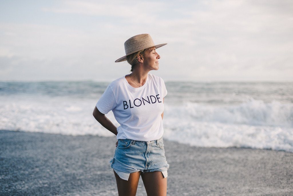 Yoga instructor Ally Maz photographed on the beach in a white Brunette the Label tshirt.